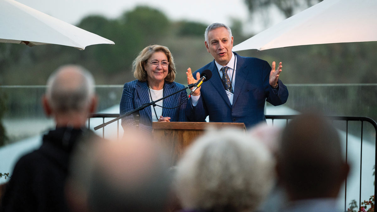 Chancellor Assanis and wife Eleni speaking during a development event
