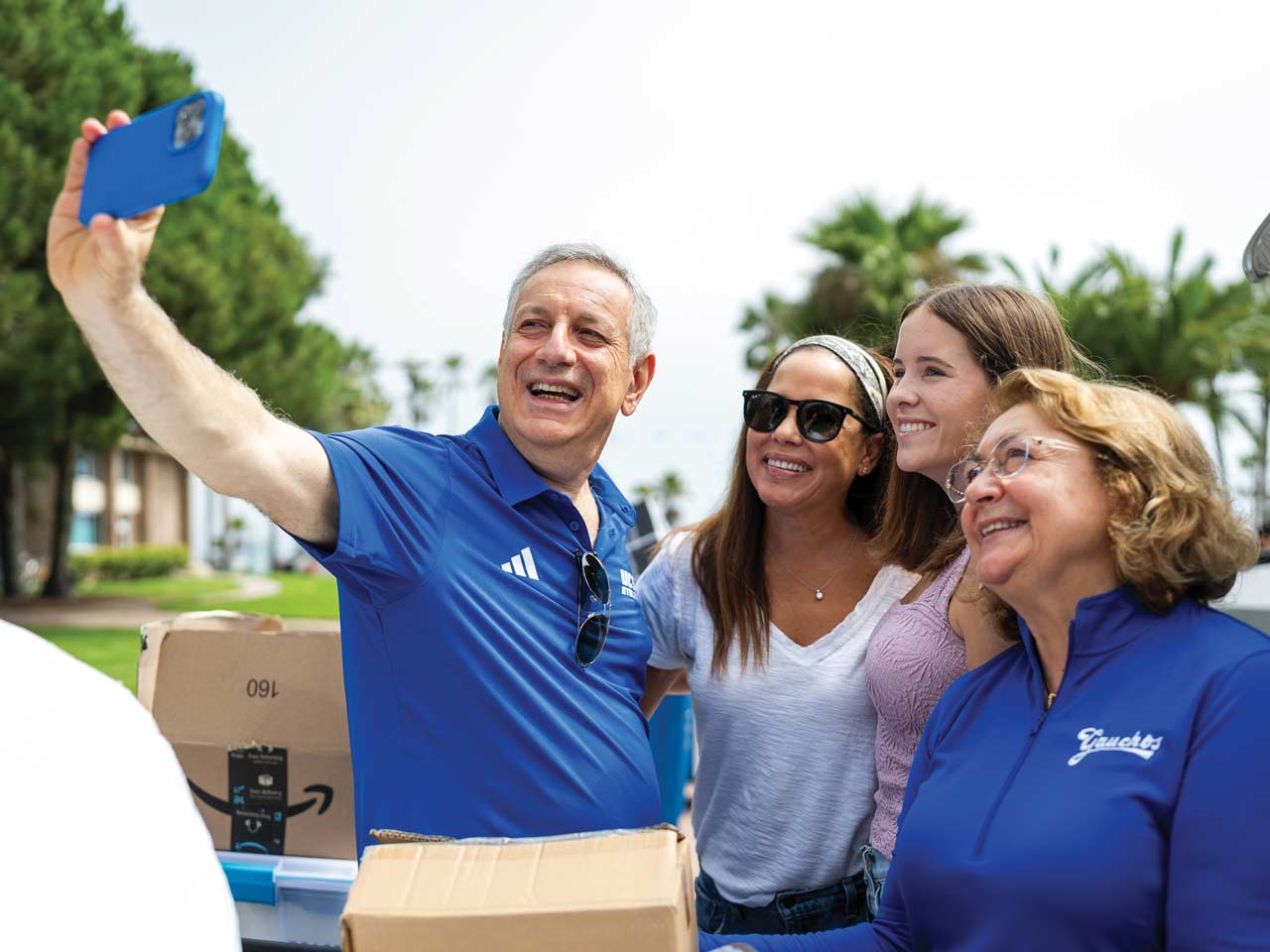 Chancellor Assanis and his wife Eleni pose for a selfie with a mother and daughter during move in weekend