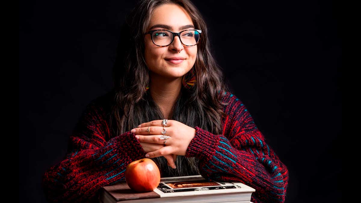 Victoria Rivera sitting with books and apple