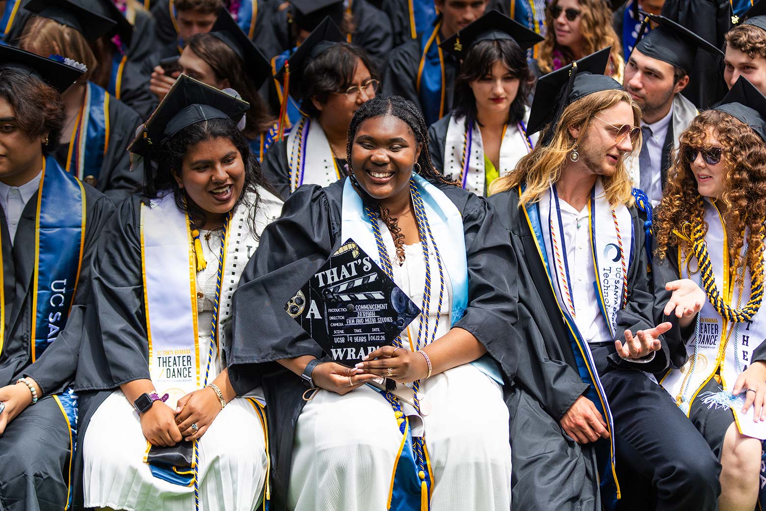 graduates at commencent and a cap that says "that's a wrap" with movie slate