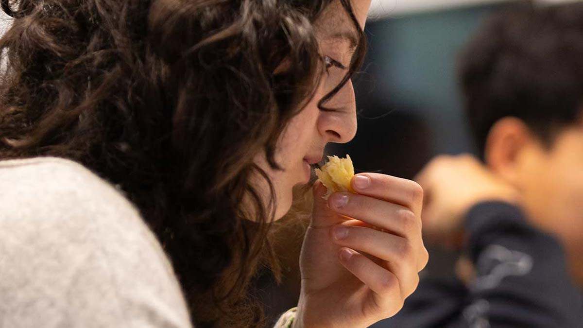 A student smells a piece of pannetone