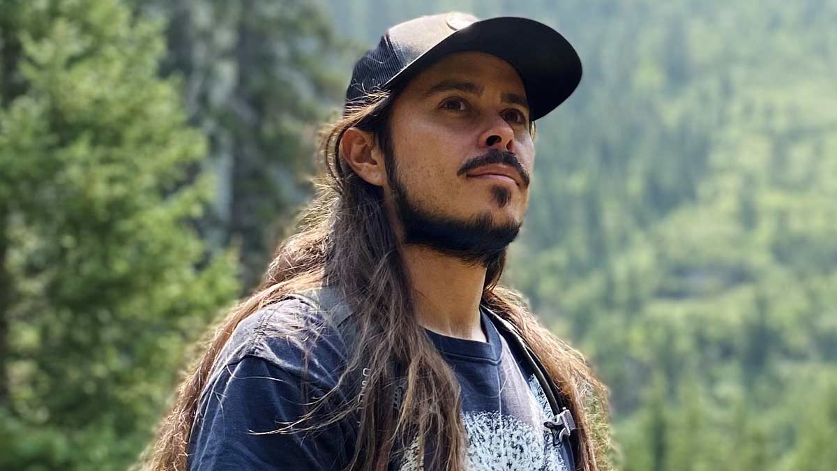 Cameron Alexander with cap on looking at the mountains
